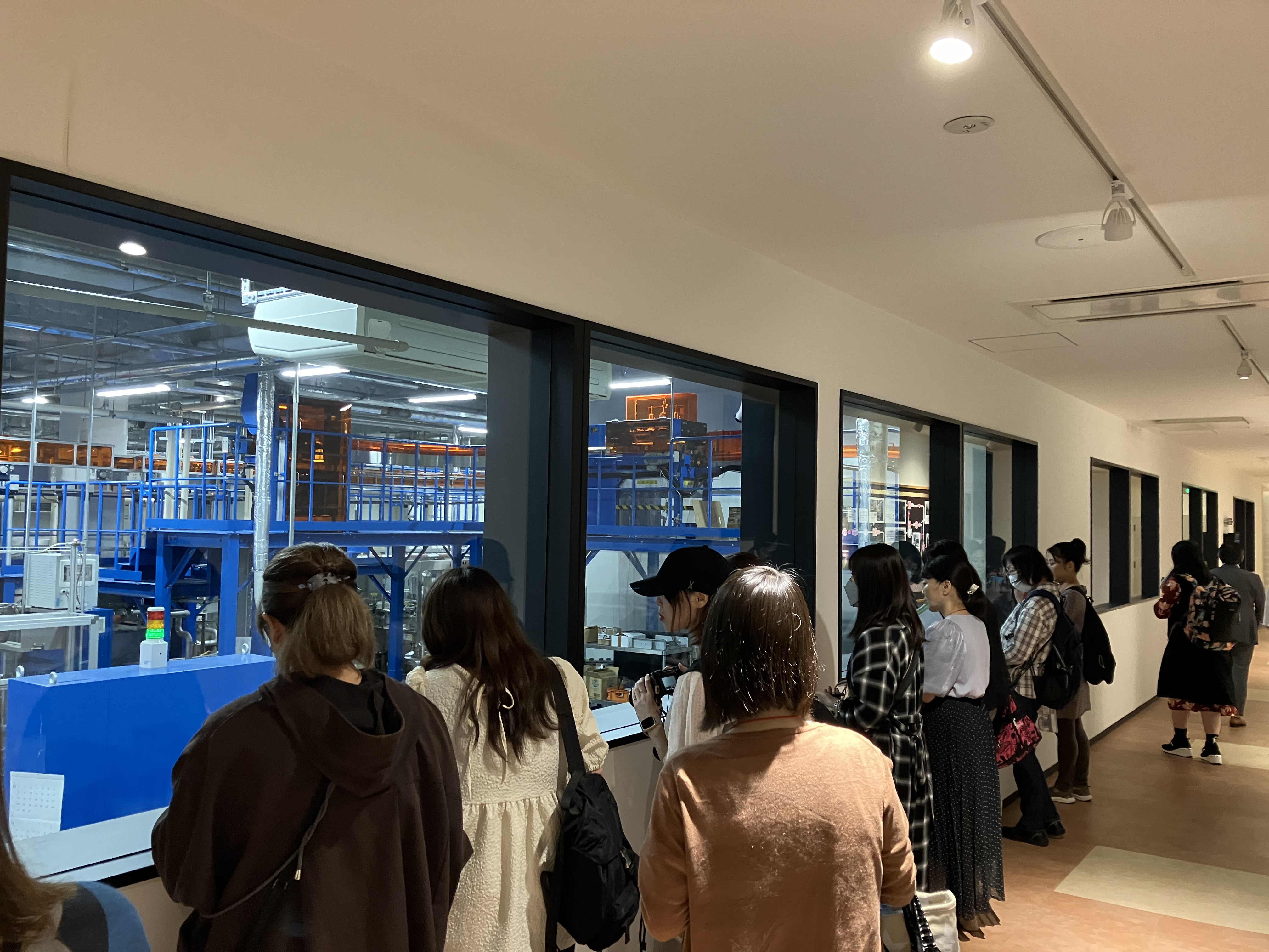 イベント当日の様子。「黄桜 伏水蔵」見学でガラスの仕切り外から蔵の様子を覗き込む人々