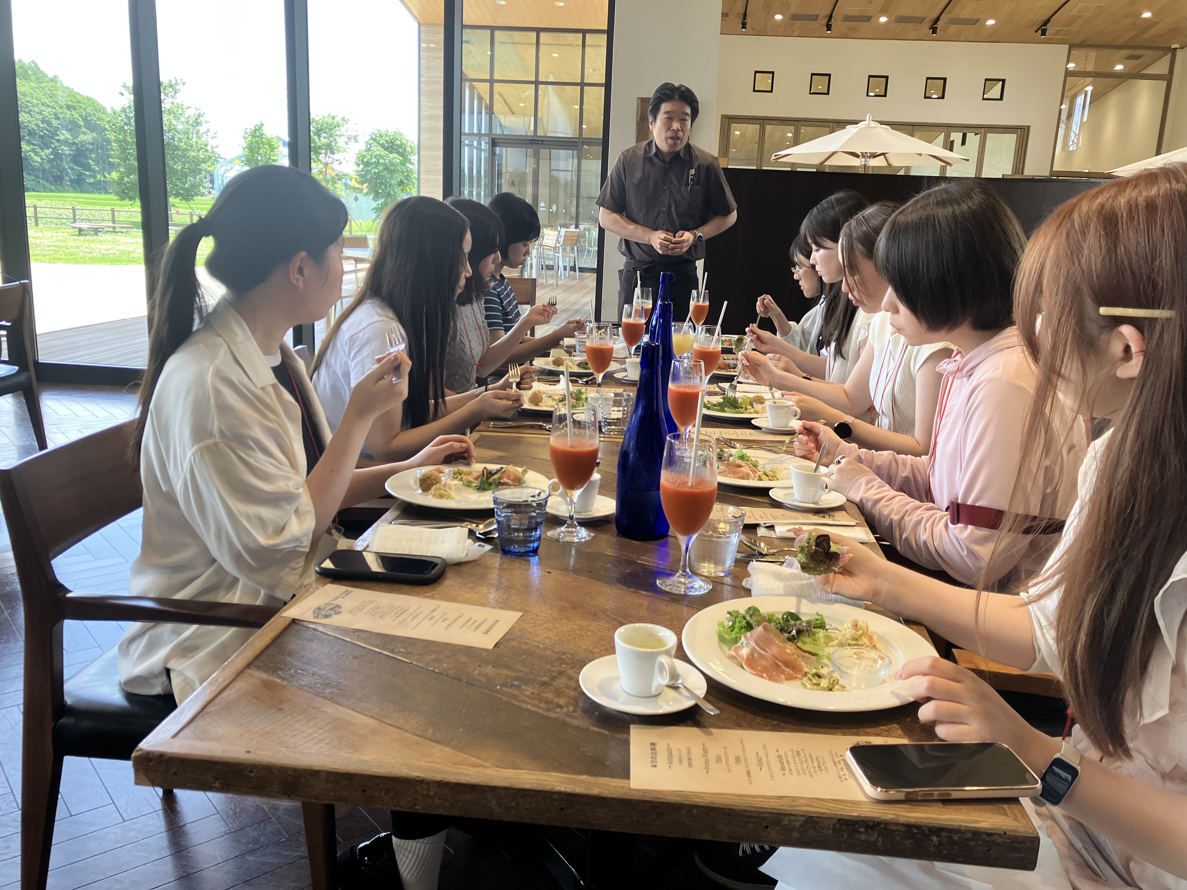 イベント当日の様子。フランス料理の様なイベント限定の特別ランチを食べる参加者たち。シェフの様な人物から説明を受けている様子。